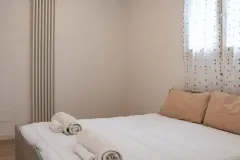 Camera da letto matrimoniale luminosa e moderna con asciugamani pronti per gli ospiti