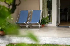 Zona relax esterna con sdraie e accesso diretto al giardino dell'appartamento