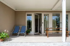 Patio esterno esposto a sud attrezzato con sdraie e tavolino per l'alloggio vacanze